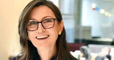 Cathie Wood, criadora da Ark Invest e evangelizadora do Bitcoin, usando óculos e sorrindo