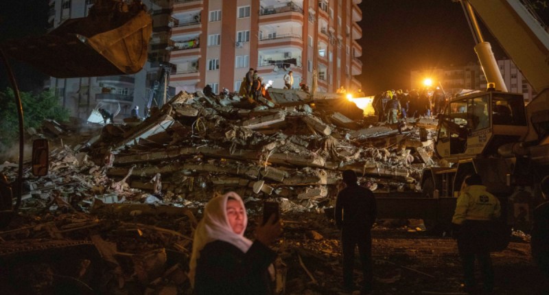 Mulher à frente do prédio destruído no terremoto do dia 6 de fevereiro de 2023 em Adana na Turquia