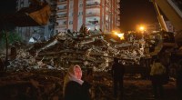 Mulher à frente do prédio destruído no terremoto do dia 6 de fevereiro de 2023 em Adana na Turquia