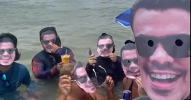 Pessoas em lagoa com máscaras com rosto de Antonio Neto Ais-Brasicompany