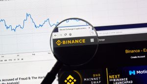 Lupa destaca nome Binance em tela de computador