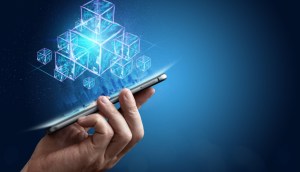 Mão segura smartphone que projeta blocos azuis