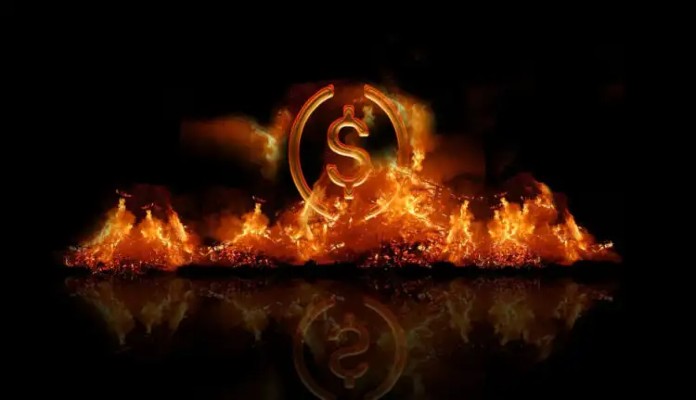 Símbolo da stablecoin USDC queimando entre chamas