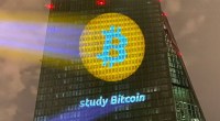 Logotipo do Bitcoin projetado no prédio do Banco Central Europeu com a frase "Study Bitcoin"