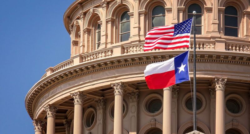 Bandeiras dos EUA e do estado do Texas no edifício do Capitólio em Austin