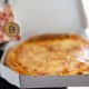 Pizza em uma mão moeda de bitcoin na outra