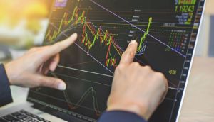 Trader operando gráficos financeiros via touch screen