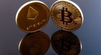 moedas de bitcoin e ethereum sobre mesa envernizada