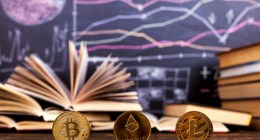 moedas de bitcoin, ethereum e litecoin à frente de quadro negor, sob mesa de sala de aula