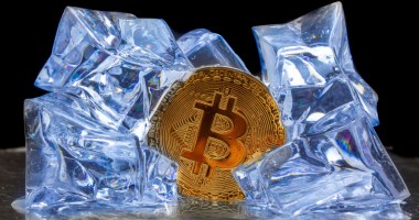 Moeda de Bitcoin envolta a pedras de gelo