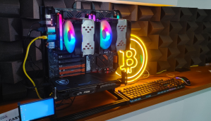 Equipamento de mineração com CPU em uma mesa de escritório com sinal luminoso do Bitcoin atrás