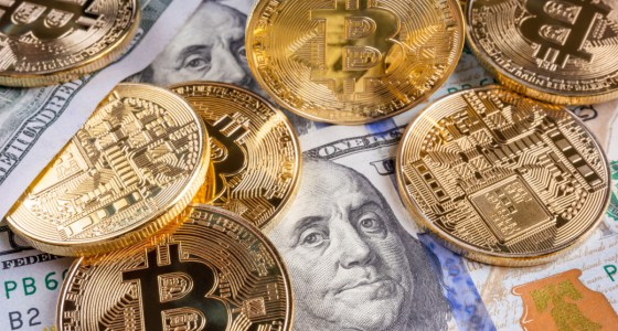mescla de dólares e moedas de bitcoin sobre a mesa