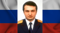 Foto do ex-investigador Russo Marat Tambiev com a bandeira da Rússia ao fundo