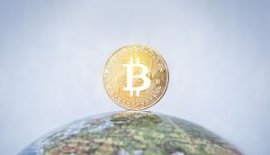 moeda de Bitcoin em cima de globo terrestre e mundo