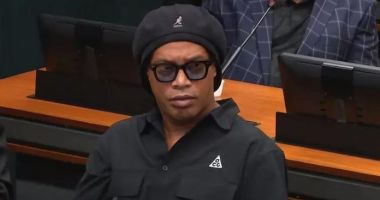 Ronaldinho Gaúcho de boina e camisa preta e óculos escuros na Câmara dos Deputados durante sessão da CPI das Pirâmides Financeiras