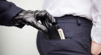 Mão com luva preta subtraindo carteira de bolso traseiro de calça masculina