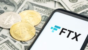 sob notas de dólares estão moedas de bitcoin, ethereum, ao lado de celular com logo FTX