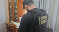 Agente da Polícia Federal dentro de residência fazendo anotações