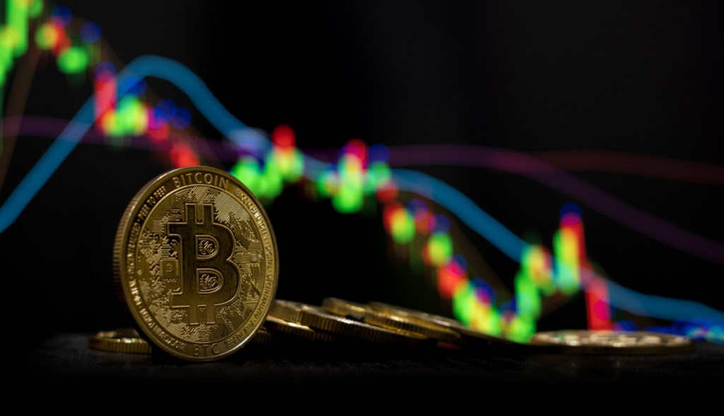 moeda de bitcoin com gráfico de queda ao fundo