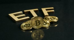 Moedas de bitcoin sob mesa escura com sigal ETF