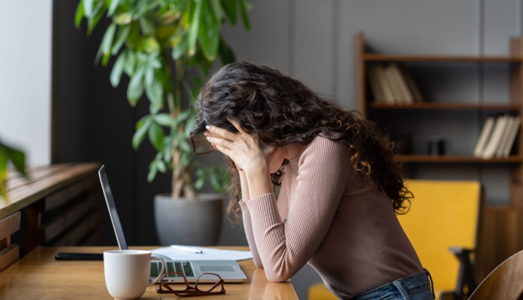 Mulher exausta diante do laptop
