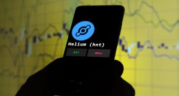 celular com logo da criptomoeda helium e grafico amarelo no fundo