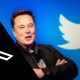 Elon Musk sorri no meio dos logotipos do Twitter e X