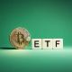 moeda de Bitcoin ao lado de letreiro com ETF