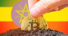 Moeda de Bitcoin semienterrada à frente de bandeira da Etiópia