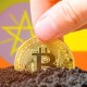 Moeda de Bitcoin semienterrada à frente de bandeira da Etiópia