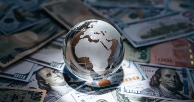 Globo envolto a notas de dinheiro de vários países