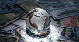 Globo envolto a notas de dinheiro de vários países