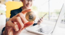 mulher desfocada mostra moeda de bitcoin