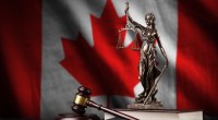 Estátua da justiça e martelo de juiz à frente de bandeira do Canadá