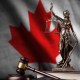 Estátua da justiça e martelo de juiz à frente de bandeira do Canadá