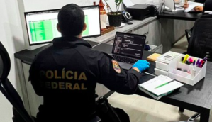 Agente da PF manuseia computador