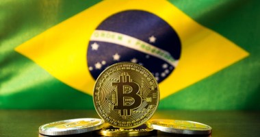 moeda de bitcoin com bandeira do brasil ao fundo (2)