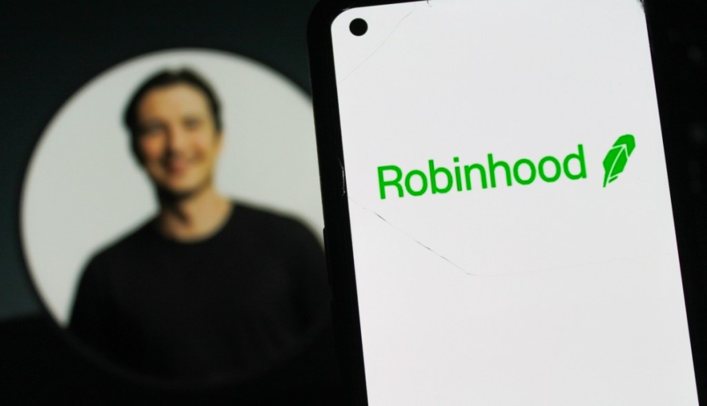 Logotipo da Robinhood em um smartphone, com a foto de perfil do CEO Vladimir Tenev ao fundo