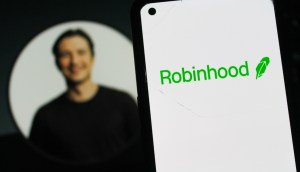 Logotipo da Robinhood em um smartphone, com a foto de perfil do CEO Vladimir Tenev ao fundo
